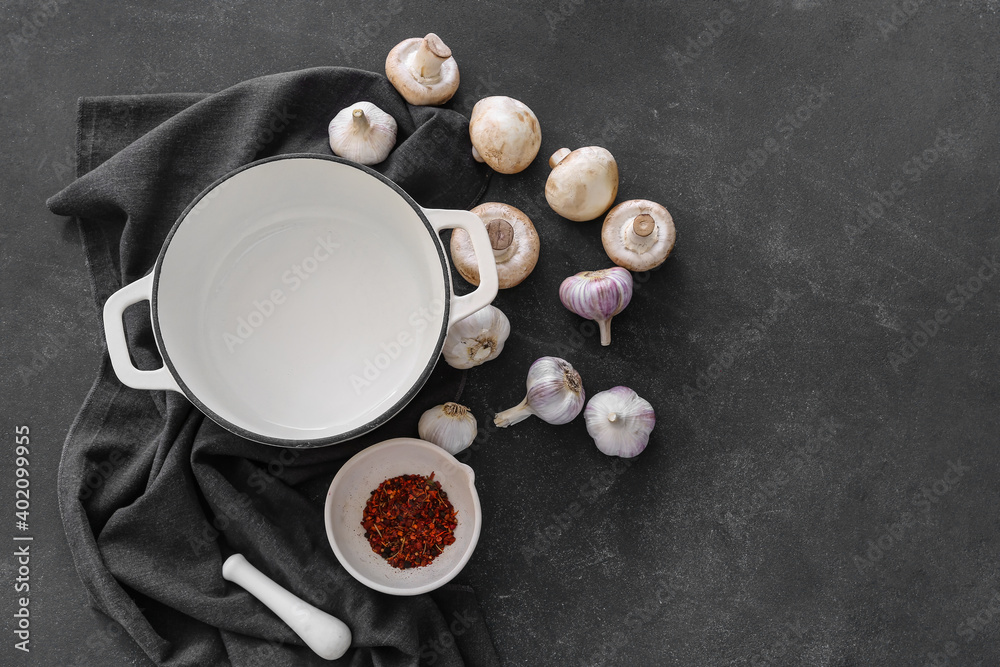 Cooking pot and mushrooms on dark background