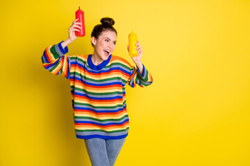 Sticker - Photo of funky girl wear rainbow striped sweater jeans hold ketchup mustard dance copyspace isolated on yellow color background