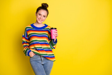 Canvas Print - Photo of nice optimistic brunette girl stand hold cup hand in pocket wear rainbow sweater blue pants isolated on bright yellow background