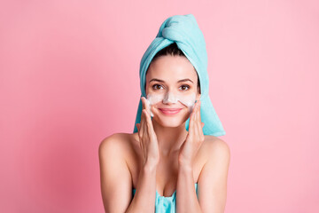 Wall Mural - Portrait of young cheerful good mood lovely girl apply foam on cheeks wear teal turban isolated on pink color background