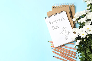 Sticker - Notebook with phrase Teacher's Day and beautiful white flowers on light blue background, flat lay. Space for text