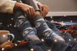 © New Africa - Woman wearing knitted socks on warm plaid indoors, closeup. Cozy season