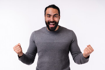 Wall Mural - Happy excited young Arabian man in casual attire isolated over white background