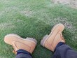 © Muhammatromsi - walking in the grass. Timberland brand men's shoes on green grass.