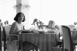 1977 vintage, seventies, retro monochrome image of a young mother and girl with blond hair sitting at a dining table in a restaurant of a hotel in Romania.