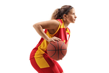 Wall Mural - Profile shot of a female basketball player in a red and yellow jersey with a ball