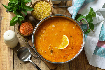 Turkish cuisine. Traditional soup with rice, lentils and mint on a rustic table.