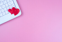Two Red Hearts And A Keyboard, On A Pink Background. Online Dating. Valentine's Day