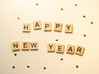 Happy new year - napis z drewnianych kostek, confetti, białe tło, flatlay  