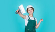 © be free - cheerful child laborer using building uniform and plastering spatula, labor day