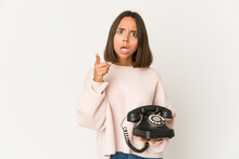 Young Hispanic Woman Holding A Vintage Telephone Isolated Having An Idea, Inspiration Concept.