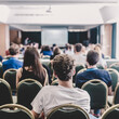 © kasto - Speaker giving presentation in lecture hall at university. Participants listening to lecture and making notes.