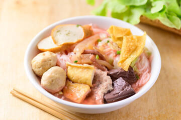 Thai food (Yen Ta Fo), Rice noodles soup with red sauce and fish tofu, pork ball and fried wonton in a bowl