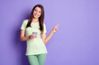 © deagreez - Photo portrait of young brunette using smartphone showing with finger at blank space smiling isolated on vibrant violet color background