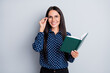 © deagreez - Portrait of lovely cheerful businesslady reading science book touching specs isolated over grey pastel color background