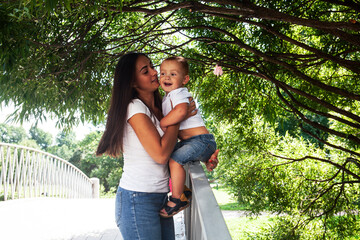 young pretty brunette mother with little cute boy walking in park happy smiling, lifestyle people concept