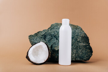 Coconut and a tube of cosmetics on a stone background