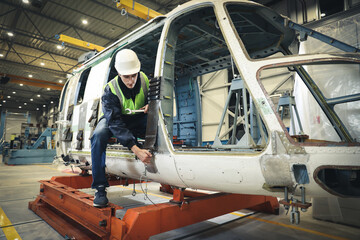 Portrait of a Caucasian man , factory engineer in work clothes controlling the work process at the helicopter manufacturer. 