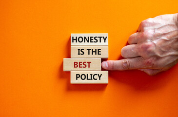 Honesty is the best policy symbol. Wooden blocks. Text 'honesty is the best policy', businessman hand. Beautiful orange background, copy space. Business and honesty is the best policy concept.