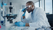 © Gorodenkoff - Medical Development Laboratory: Black Male Scientist Looking Under Microscope, Inspecting Petri Dish. Professionals Working in Advanced Scientific Lab doing Medicine, Vaccine, Biotechnology Research