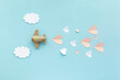 Happy Valentines day. Toy airplane aircraft on blue background with white clouds and pink hearts.