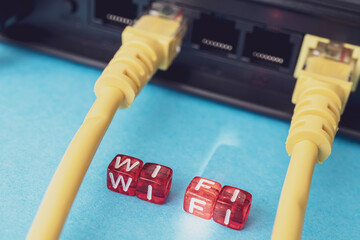 a router with yellow patch cords inserted into it and cubes on top of which wifi is written