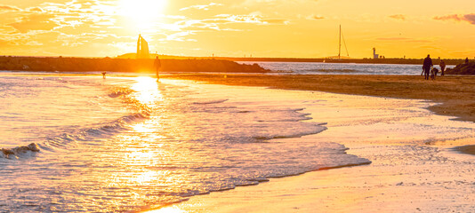 Wall Mural - Panorama d'un coucher de soleil sur une plage avec vue sur le phare de La Grande Motte, sud de la France près de la Camargue.