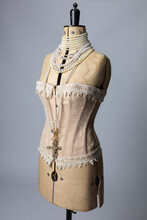 A Vintage Dressmakers Dummy Wearing A Corset And Pearl Necklaces