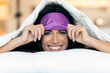© nenetus - Pretty young woman pulling up sleeping mask while looking at camera after wake up in the bedroom at home.