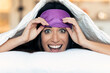 © nenetus - Pretty young woman pulling up sleeping mask while looking at camera after wake up in the bedroom at home.