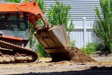 Mini bulldozer with earth doing landscaping works