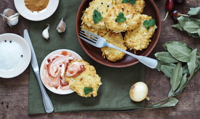 Top view of potato pancakes, a national dish of Belarus, Ukraine and Russia.On a wooden background, pancakes, potato pancakes or pancakes, surrounded by sauce, salted fish and seasoning.