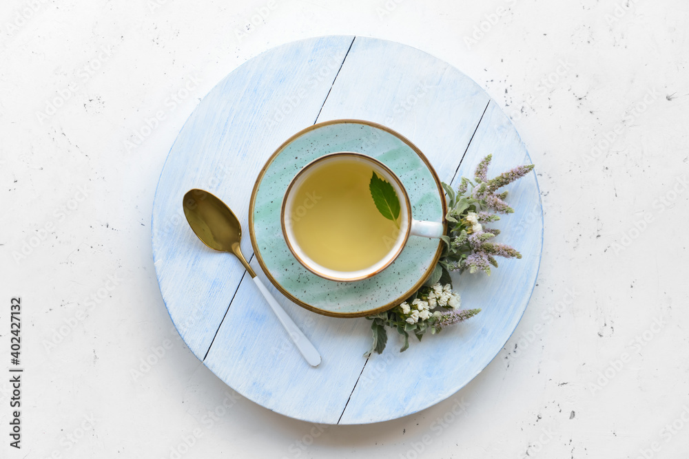 Cup with herbal tea on light background