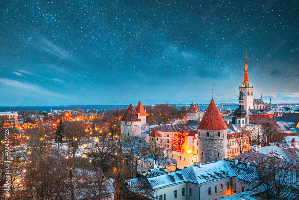 Tallinn, Estonia. Night Starry Sky Above Old Castle Walls Architecture. Cityscape Skyline In Old Town. Winter Evening Night. Famous Landmark. Popular Destination Scenic. UNESCO Heritage. Altered Sky. - obrazy, fototapety, plakaty 