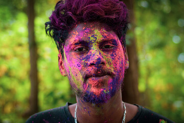  A young man with face full of colours enjoying holi celebration.Concept for Indian festival Holi..