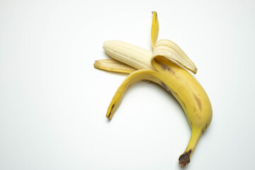 Wall Mural - one ripe and open banana lies on a white background