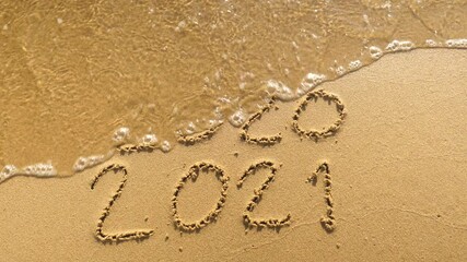 Wall Mural - message year 2020 replaced by 2021 written on beach sand background. good bye 2020 hello to 2021 lap