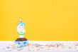 6 number candle on a cup cake with colorful sprinkles and yellow background sixth birthday anniversary celebrations