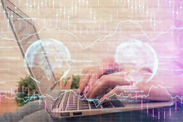 Multi exposure of woman hands typing on computer and forex chart hologram drawing. Stock market analysis concept.