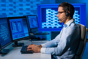 Call-center worker is speaking with the client by headset. Workplace of the professional support operator in office.