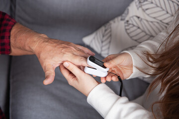 Close up of measuring pulse rate and oxygen levels with finger oximeter.