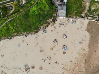 Wall Mural - Looking down on a golden sand beach with lots of families congregated together