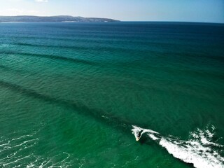 Wall Mural - A surfer performing a cutback on a small green wave at Gwithian