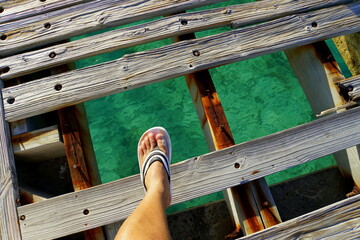 Walking on a broken bridge above the crystal clear green ocean near Grand Turk, Turks & Caicos