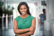 © F Armstrong Photo - African American woman in green dress in modern corporate building lobby