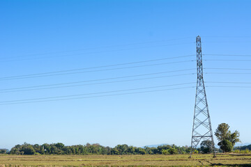 High-voltage transmission tower and electricity voltage wiring cable with sky background.