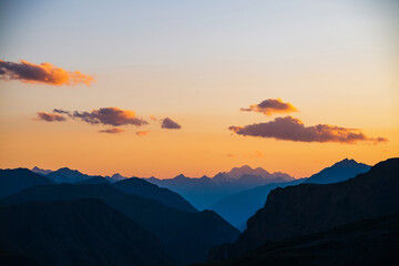 Wall Mural - colorful dawn landscape with beautiful mountains silhouettes and golden gradient sky with lilac clou