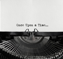 Leinwandbilder - Mechanical typewriter at the center with a white sheet of paper. Metallic type machine with written text Once upon a time. Fairy tale concept. Storytelling idea is written with a classic typewriter.