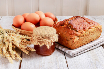 Sticker - Loaf of bread and basket of eggs on white wooden table.