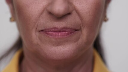 Canvas Print - Close-up old woman's sad face. Beautiful teeth and lips of the old woman.Slow motion video.